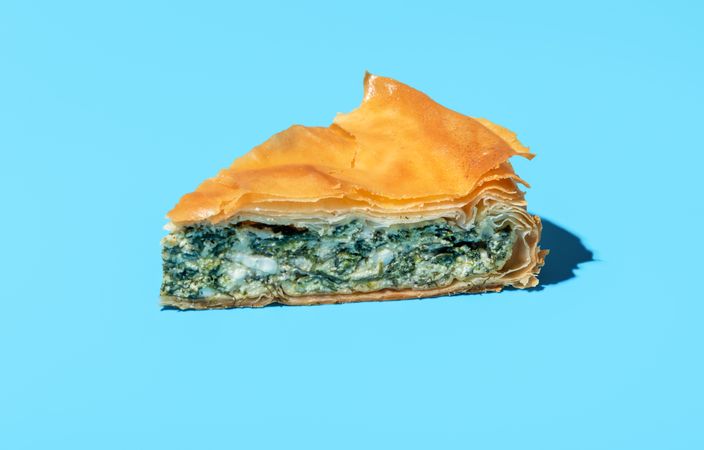 Phyllo cake slice minimalist on a blue background