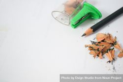 Pencil laying on table with shavings & sharpener with space for text 0yX6Zq