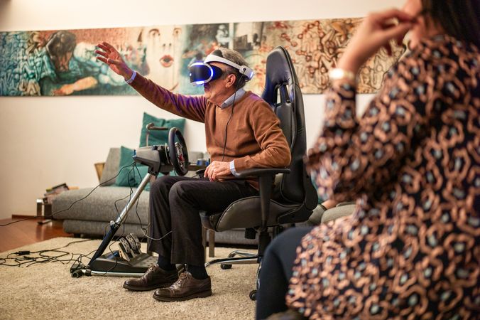 Man wearing VR headset in living room with family
