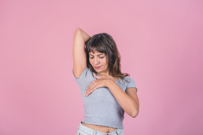Woman doing a Breast Self-Exam over pink background