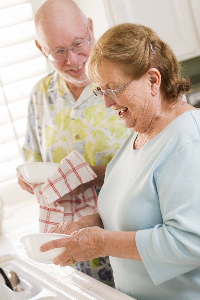 Adult Couple Washing Dishes Together Inside Kitchen
