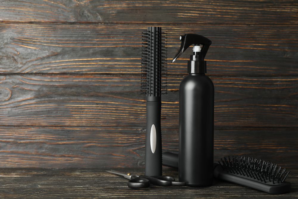 Composition with hairdresser accessories on wooden table, space for text