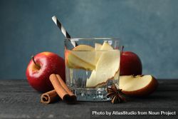 Sideview of glass of water with straw, apple slices and cinnamon slices bYZxY0