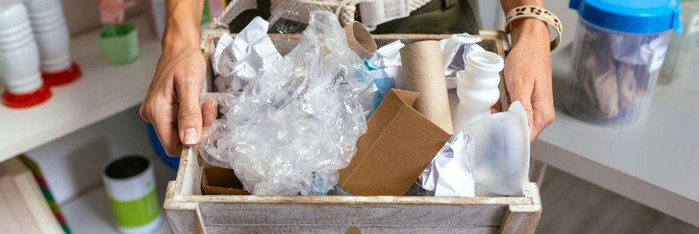 Female teacher showing a box of waste to recycle in ecology classroom
