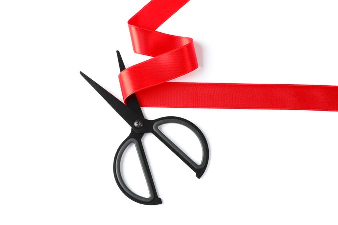 Red ribbon and scissors isolated on blank background. Gift concept