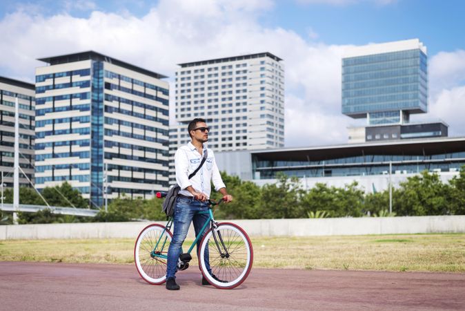 Male with colorful bicycle on city bike path on sunny day