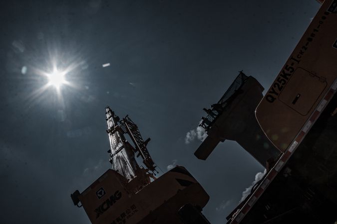 Heavy truck machines and crane under dark blue sky