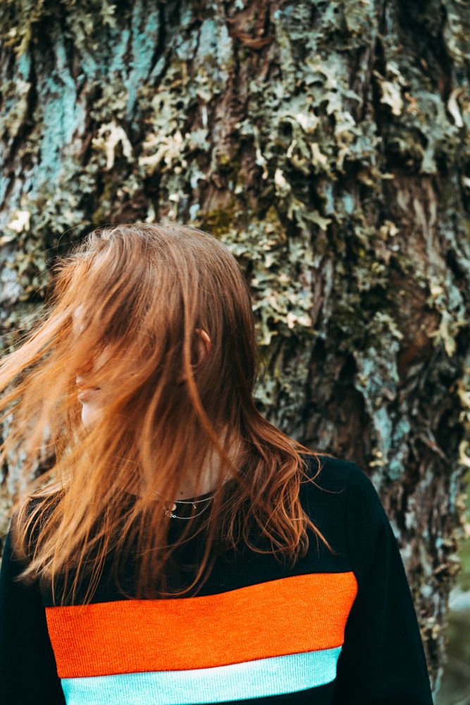 Casual redhead woman shaking with hair