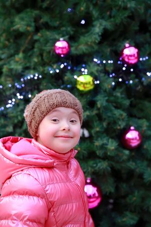 Excited child standing with a decorated holiday tree