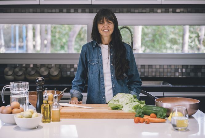 woman housewife preparing meal while looking at camera
