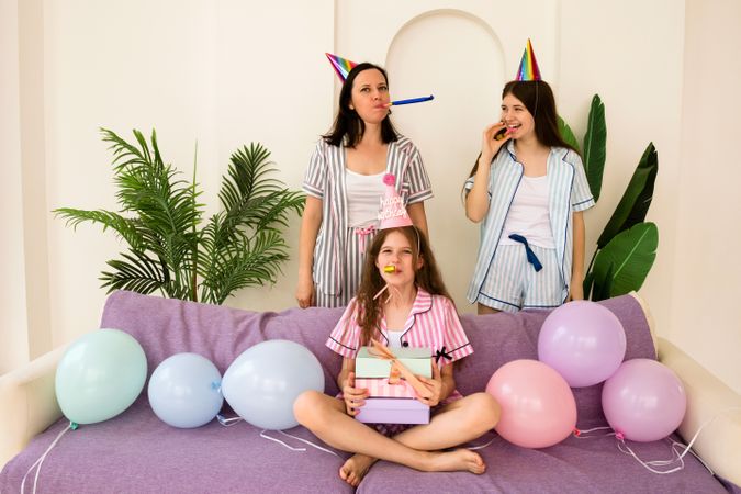 Family sitting with party decorations celebrating birthday at home.