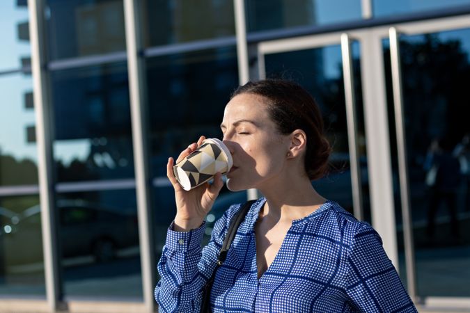 Businesswoman drinking on city street