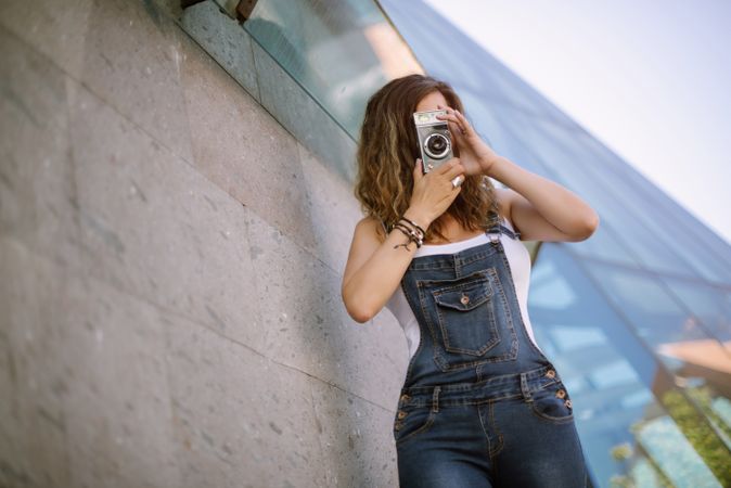 Creative woman taking photo on camera in sunny day