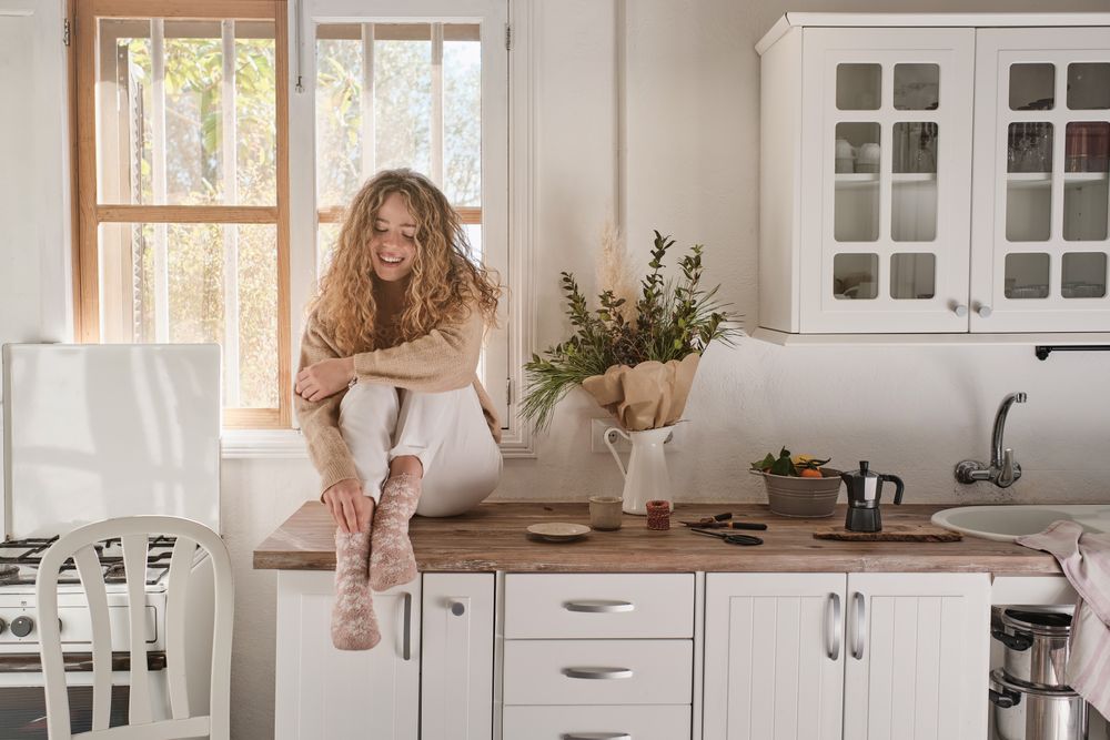 Young woman sitting in kitchen