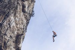 Anonymous climber handing on cliff