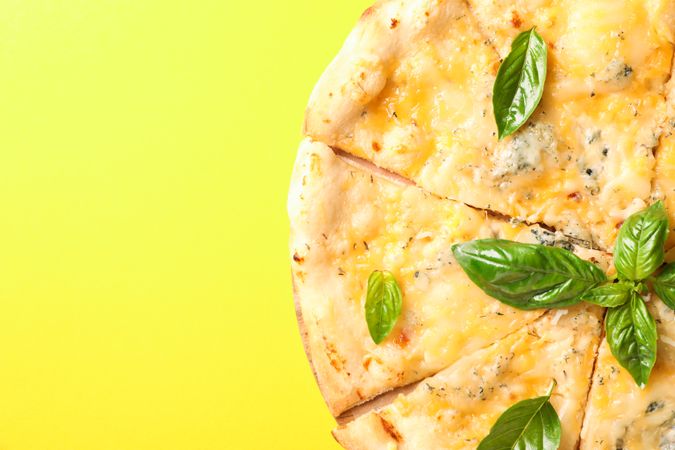 Cheese pizza on yellow background, copy space