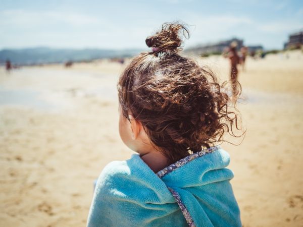 back view of little girl looking at sea