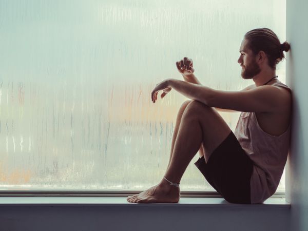 Man in mindfulness on window sill