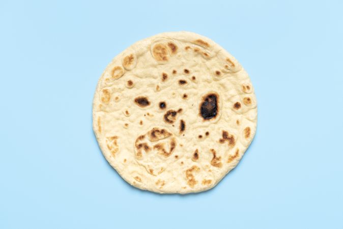Naan bread isolated on a blue background