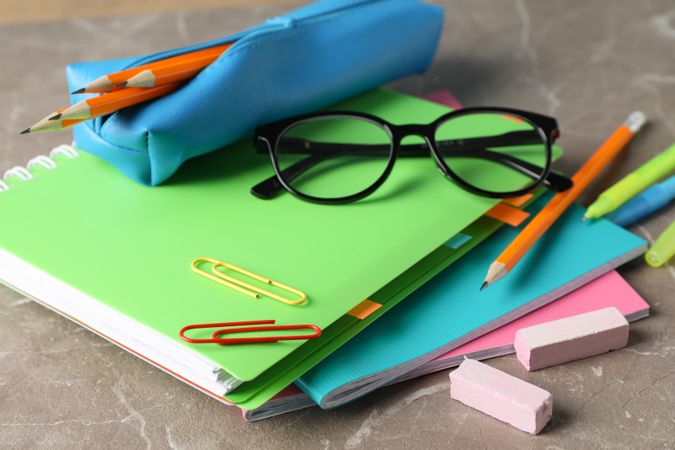 Pile of colorful notebooks with pencils and stationary