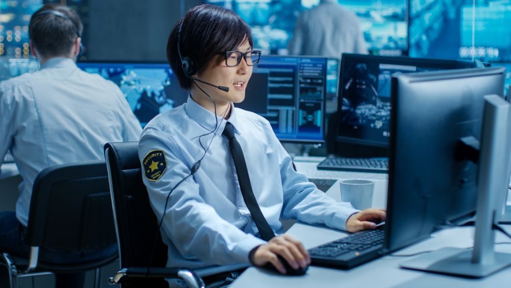 In the Security Command Center Officer at His Workstation Monitors Screens and Communicates with Patrols through Headset.
