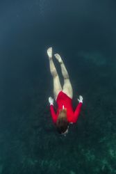 Woman diving in blue clean water