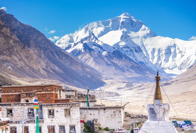 Shabby houses and temple near snowy mountain