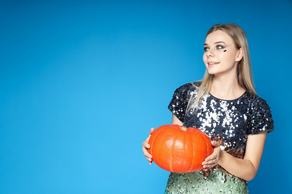 Concept of Halloween, young woman on blue background