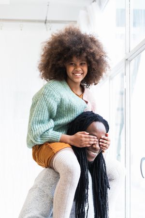 Black girl playing game with father and laughing happily