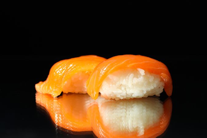 Delicious sushi rolls on dark mirror background. Japanese food