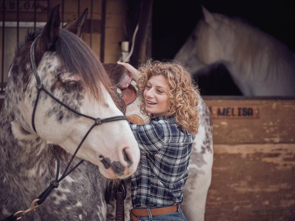 Cheerful woman standing near horse