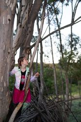 Little girl standing in tree branches and looking out