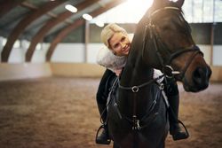 Young female jockey training with her horse