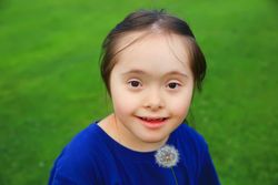 Portrait of happy girl holding a dandelion