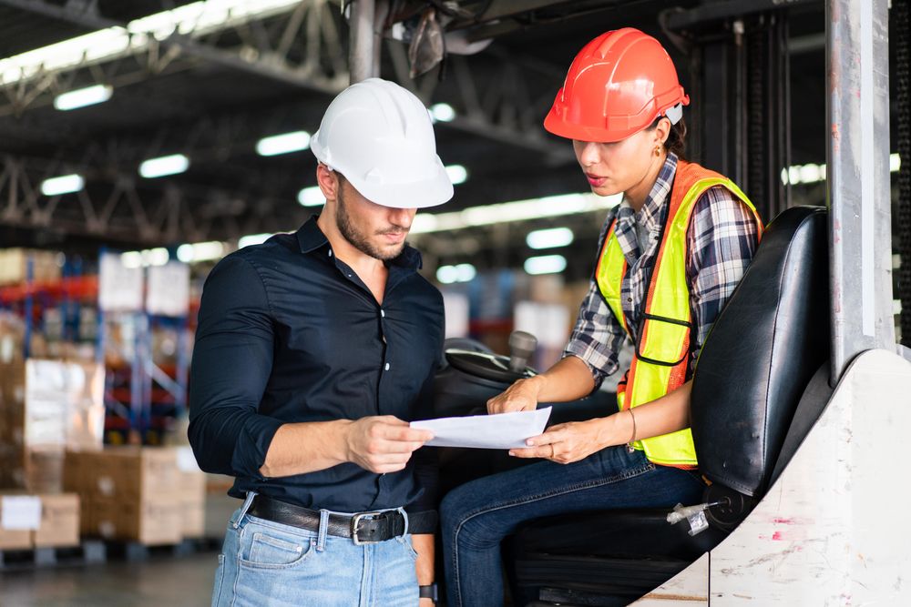 Two colleagues going through inventory list in distribution center