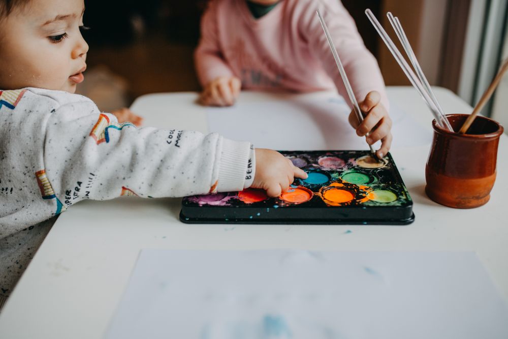 Side view of little boy touching paint palette