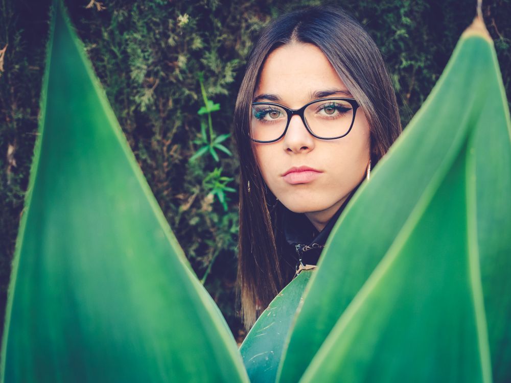 Woman between green leaves