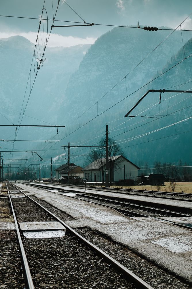 Railway passing along houses and mountains in misty day