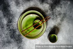 Green plates and chopsticks on grey background 4NO2mb