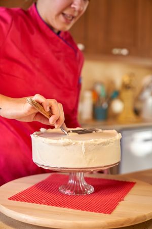 Woman in professional clothes making cake at home