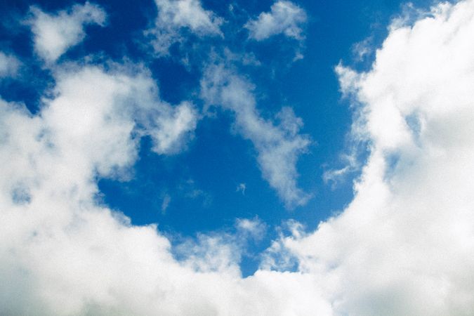 Fluffy Clouds Against A Deep Blue Sky On A Bright Sunny Day