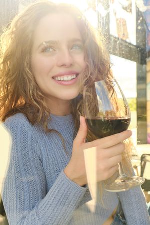 Smiling young woman with glass of wine