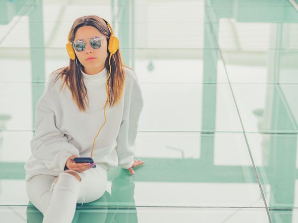 Young woman over a glasses ground with headphones and smartphones