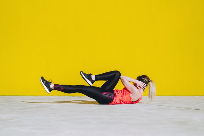 Woman doing sit ups exercises on floor