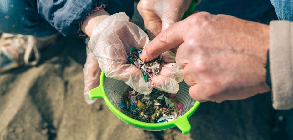 Colander with microplastics on the beach
