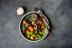 Top view of fresh organic vegetable salad on grey counter