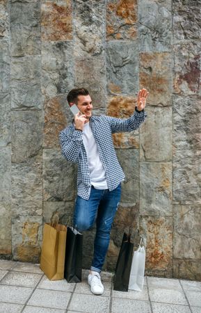 Young man with shopping bags and mobile