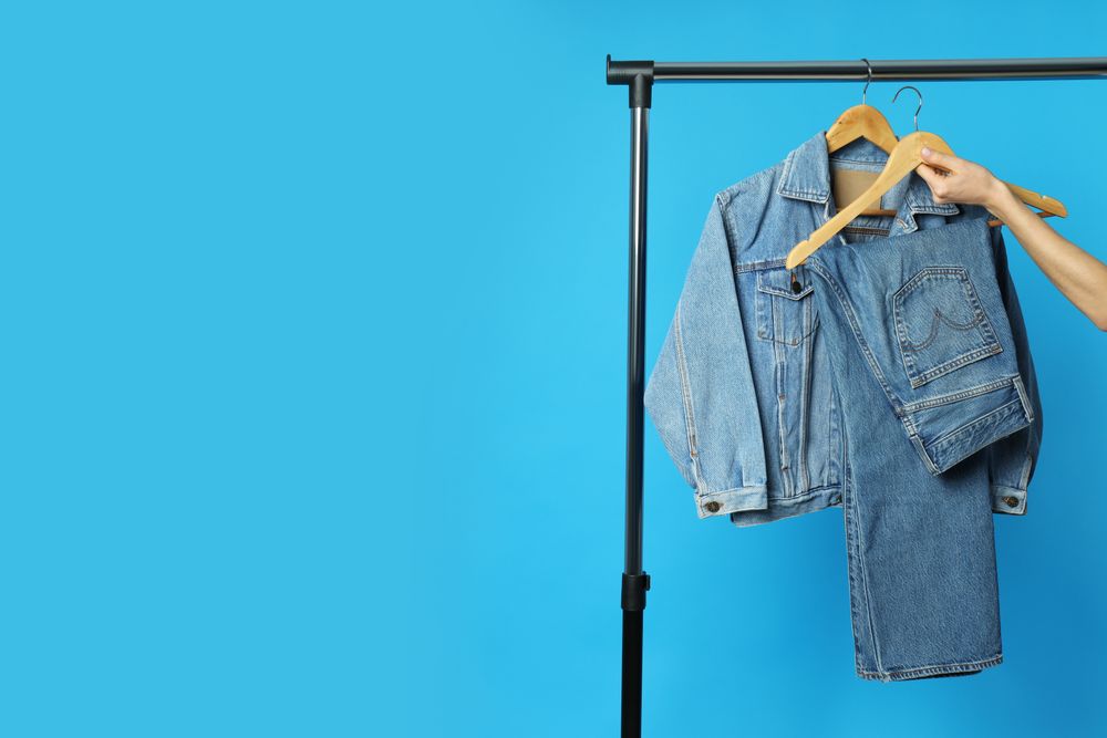 Jeans hang on hangers on a blue background