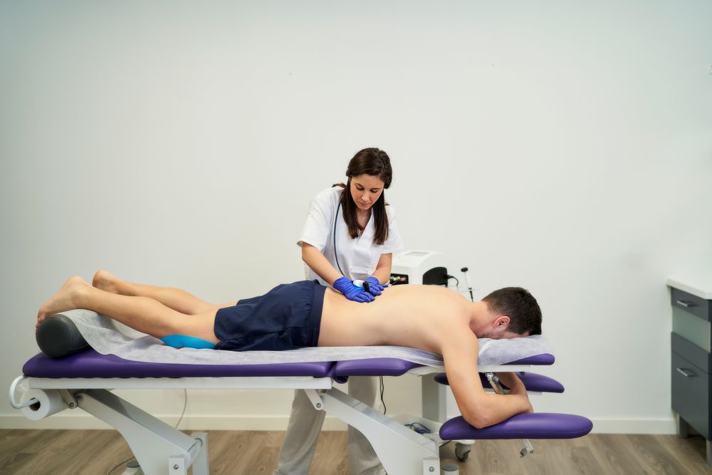 A female physiotherapist giving diathermy treatment on the patie