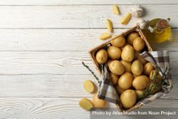 Looking down at box of potatoes on rustic background, copy space 4BpDX0